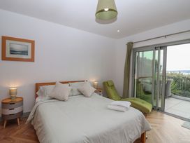 A bedroom with a bed and sliding door at Seacroft in Wellswood near Torquay