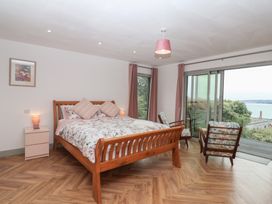 A bedroom with a bed and chairs at Seacroft in Wellswood near Torquay