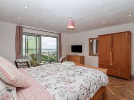 A bedroom with a bed and wardrobe at Seacroft in Wellswood near Torquay