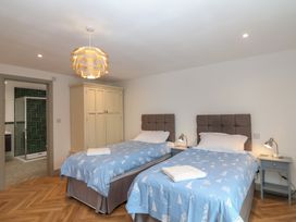 A bedroom with two beds and a wardrobe at Seacroft in Wellswood near Torquay