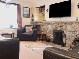 A living room with a stone wall and television at The Little Farmhouse in Carnforth