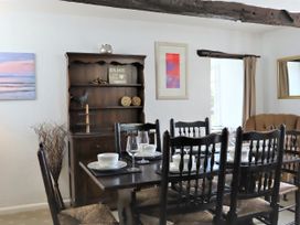 A dining room with a table set and shelves at The Little Farmhouse in Carnforth