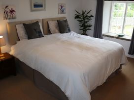 A bedroom with a large bed and a window at The Little Farmhouse in Carnforth