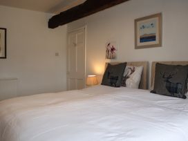 A bedroom with a bed and wall art at The Little Farmhouse in Carnforth