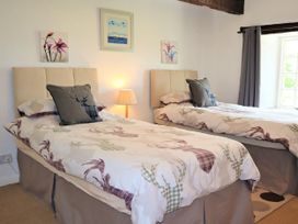 A bedroom with two beds and a lamp at The Little Farmhouse in Carnforth
