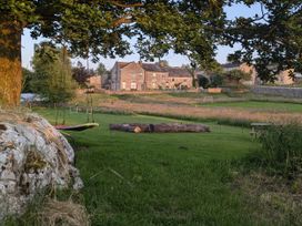 A garden with a swing and log at The Little Farmhouse in Carnforth