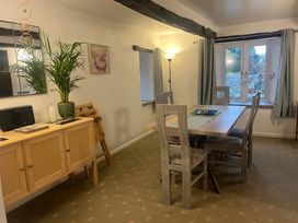 A dining room with a table, chairs, and a cabinet at The Old Farmhouse at Brackenthwaite Farm Yealand Redmayne near Arnside