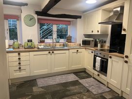 A kitchen with sink, microwave, and oven at The Old Farmhouse at Brackenthwaite Farm Yealand Redmayne near Arnside