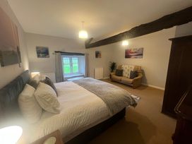 A bedroom with a bed and sofa at The Old Farmhouse at Brackenthwaite Farm Yealand Redmayne near Arnside