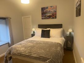 A bedroom with a bed and nightstand at The Old Farmhouse at Brackenthwaite Farm Yealand Redmayne near Arnside
