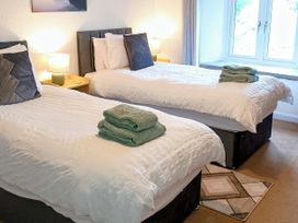 A bedroom with twin beds and towels at The Old Farmhouse at Brackenthwaite Farm Yealand Redmayne near Arnside