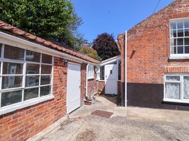 An outdoor area with brick walls and doors at Beehive in Beccles