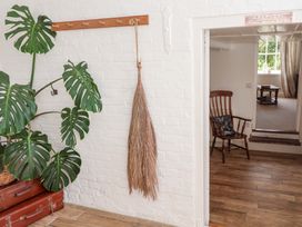 A hallway with a monstera plant and a rocking chair at Beehive in Beccles