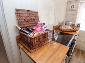 A kitchen with a basket containing champagne and snacks at Beehive in Beccles
