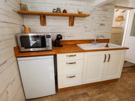 A kitchen with a microwave, refrigerator, sink and wooden countertop at Beehive in Beccles