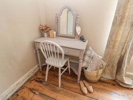 A vanity table with a mirror and chair at Beehive in Beccles