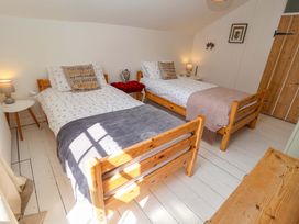 A bedroom with two beds and a wooden chest of drawers at Beehive in Beccles