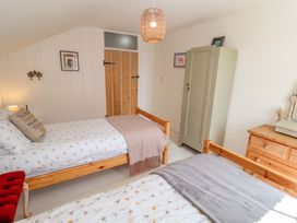 A bedroom with two beds and a wardrobe at Beehive in Beccles