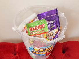 A plastic bucket with various candies at Beehive in Beccles