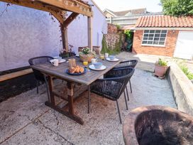 A garden with a dining table and chairs at Beehive in Beccles