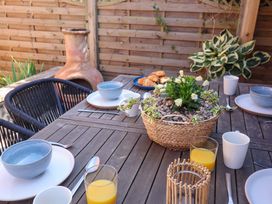 An outdoor dining table set with croissants and drinks at Beehive in Beccles