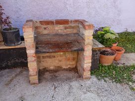 An outdoor brick barbecue with potted plants at Beehive in Beccles