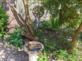 A garden with a tree and a birdbath at Beehive in Beccles
