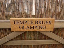 A wooden gate with a sign reading Temple Bruer Glamping at Temple Bruer near Lincoln