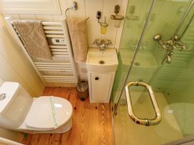 A small bathroom with a toilet a sink a glass shower and towel racks at Shepherds Hut - Ash in Temple Bruer near Lincoln