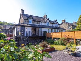 A stone and white exterior house with a balcony and garden at Dola in Pentre Du near Betws-Y-Coed