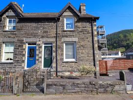 A stone exterior house with two colored front doors and metal gates at Dola in Pentre Du near Betws-Y-Coed