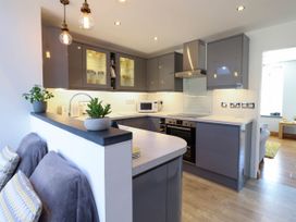 A kitchen with grey cabinets a microwave oven and plants on the counter at Dola in Pentre Du near Betws-Y-Coed