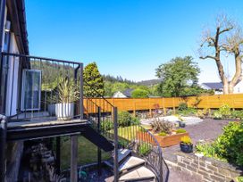 An outdoor garden with stairs leading to a patio and various plants and trees at Dola in Pentre Du near Betws-Y-Coed