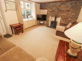 A living room with a television and a fireplace at 2 Bens Row Backbarrow near Newby Bridge