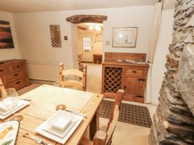 A dining room with a table and wine rack at 2 Bens Row near Backbarrow Newby Bridge