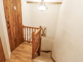 A staircase featuring wooden door and artwork at 2 Bens Row Backbarrow near Newby Bridge