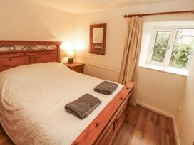 A bedroom with a bed and lamp at 2 Bens Row in Backbarrow near Newby Bridge