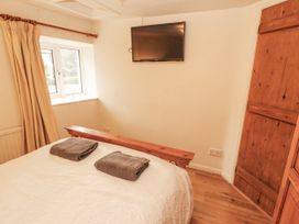 A bedroom with a bed and television at 2 Bens Row Backbarrow near Newby Bridge