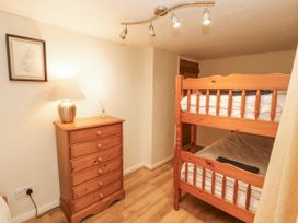 A bedroom with a bunk bed and a dresser at 2 Bens Row Backbarrow near Newby Bridge