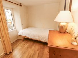 A bedroom with a bed and lamp at 2 Bens Row in Backbarrow near Newby Bridge