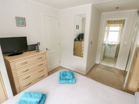 A bedroom with a television and towels on the bed at Erisa