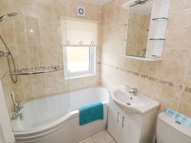 A bathroom featuring a bathtub, sink, toilet, shower, and mirror at Erisa