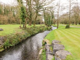 A stream running through grass and trees at Erisa
