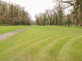 A garden with a grassy area and a pathway at Erisa in Stepaside