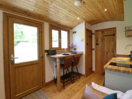 A kitchen area with a wooden door and window bar stools and a wooden countertop at Celyn in Bontddu near Dolgellau