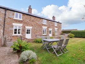 A garden with a table and chairs at Isfryn