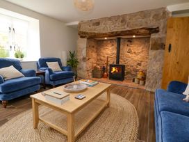 A living room with a fireplace and armchairs at Isfryn