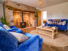 A living room with a fireplace and blue sofas at Isfryn
