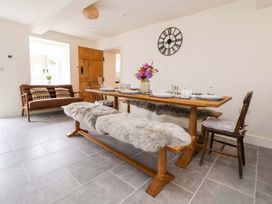 A dining room with a table and benches at Isfryn