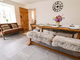 A dining room with a table and benches at Isfryn 